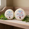 Mountain Frost shampoo and conditioner bars together on a wooden shelf with herbs